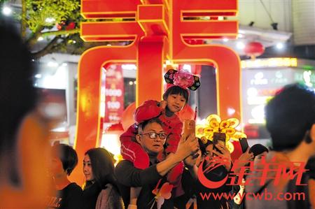 昨晚，广州西湖路花市人潮涌涌，热闹非凡，不少市民在“春”字花灯前拍照留念