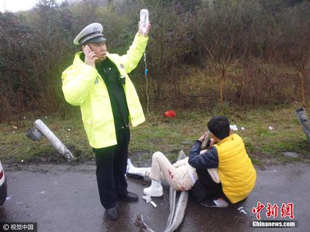 江苏镇江交警雨中边当“输液杆”边指挥交通