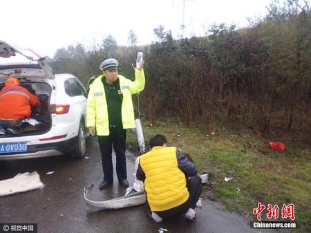 江苏镇江交警雨中边当“输液杆”边指挥交通