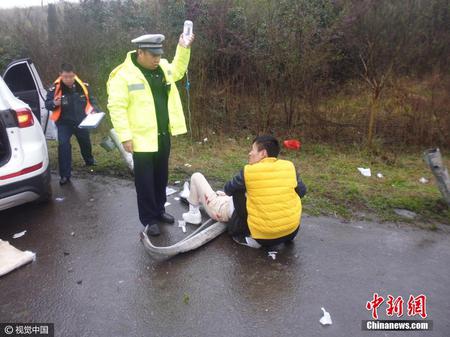 江苏镇江交警雨中边当“输液杆”边指挥交通